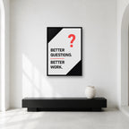 Better Questions Better Work wall art styled in a minimal workspace