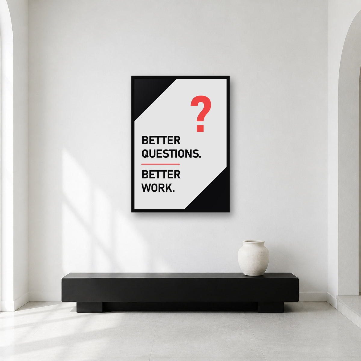 Better Questions Better Work wall art styled in a minimal workspace